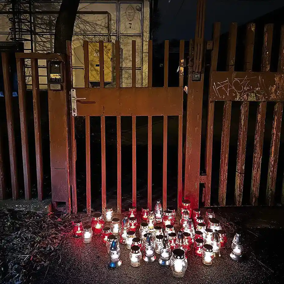 True Crime Akadémia megemlékezés, mécsesek a csepeli kettős gyilkosság helyszínének kapujánál, esti fényekben.