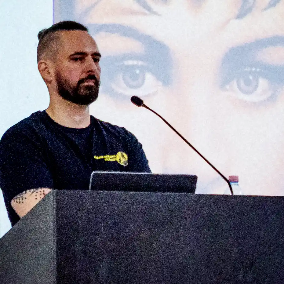 True Crime Akadémia előadója bűnügyi esetet elemez egy telt házas rendezvényen, háttérben női portréval.